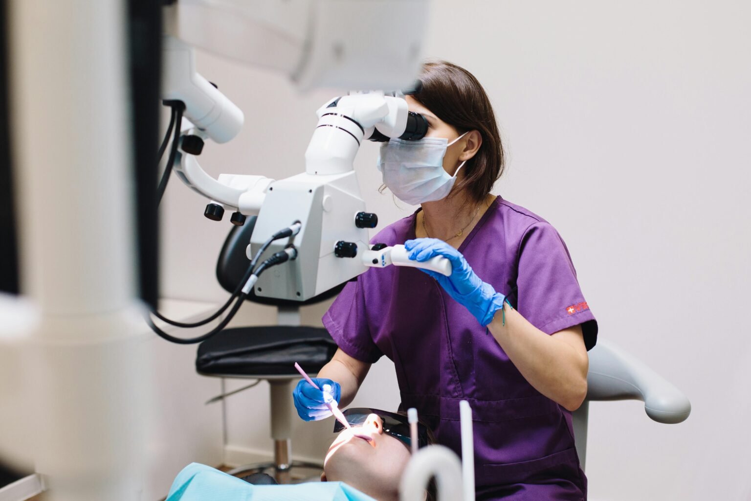 Acasa Female dentist using a microscope and modern technology during a patient examination in a dental clinic.